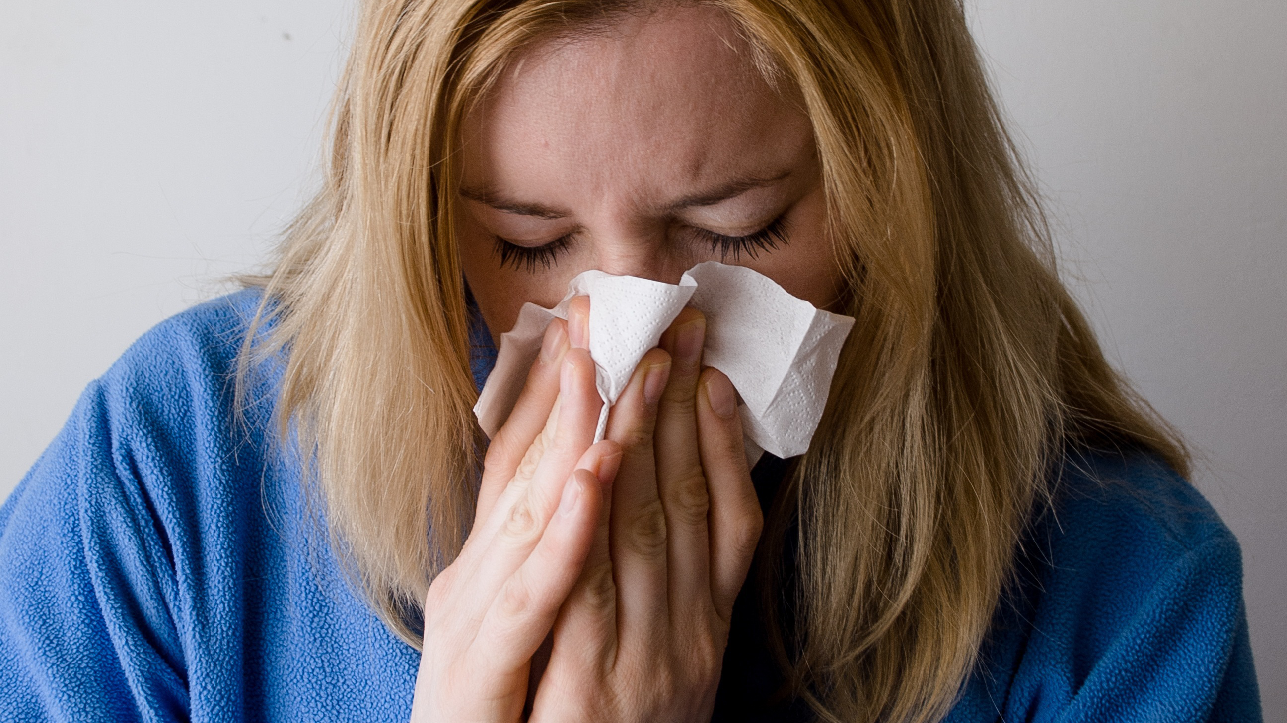 En kvinna håller tillbaka en nysning.