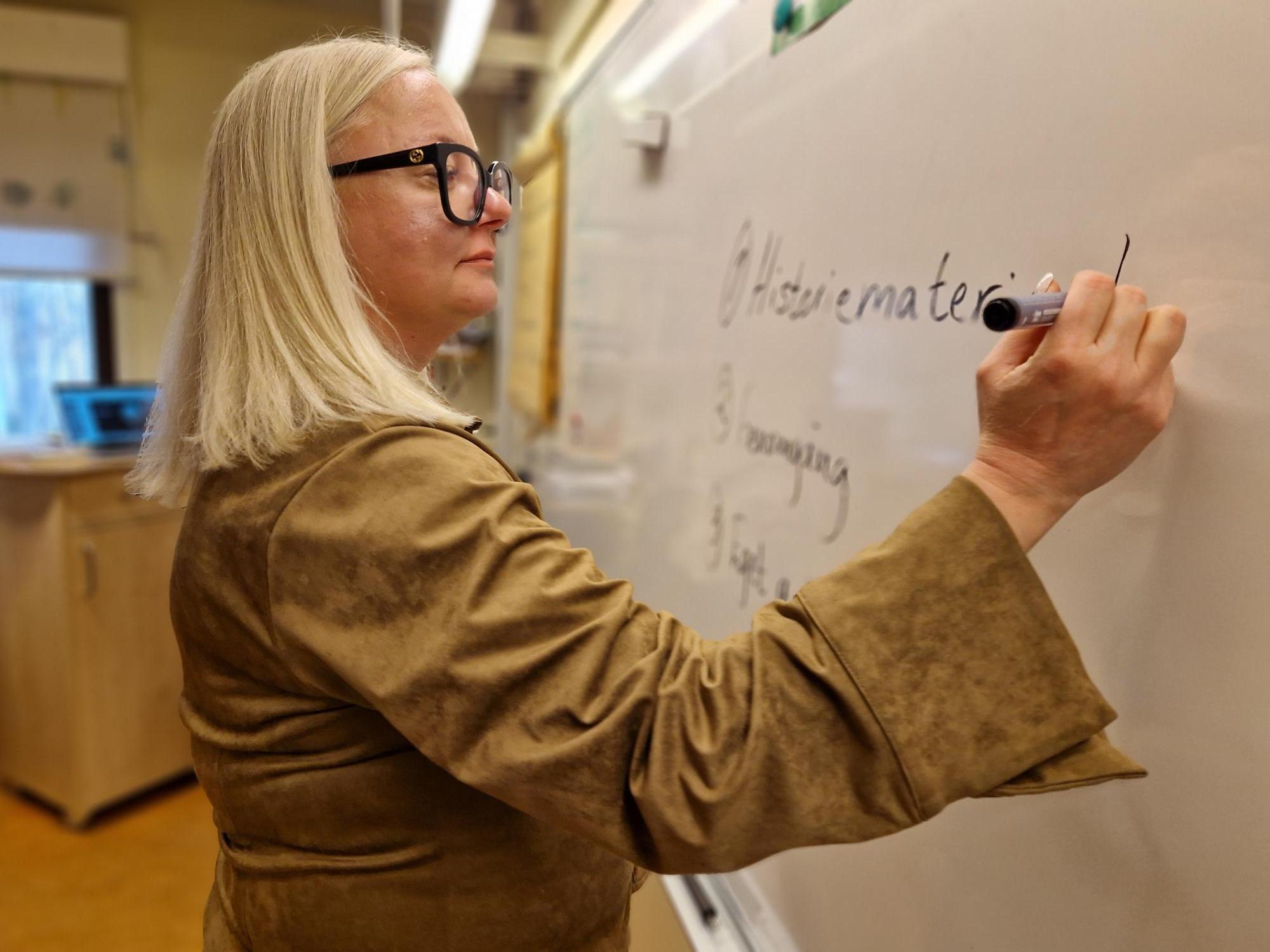 Kvinna som skriver på whiteboard.