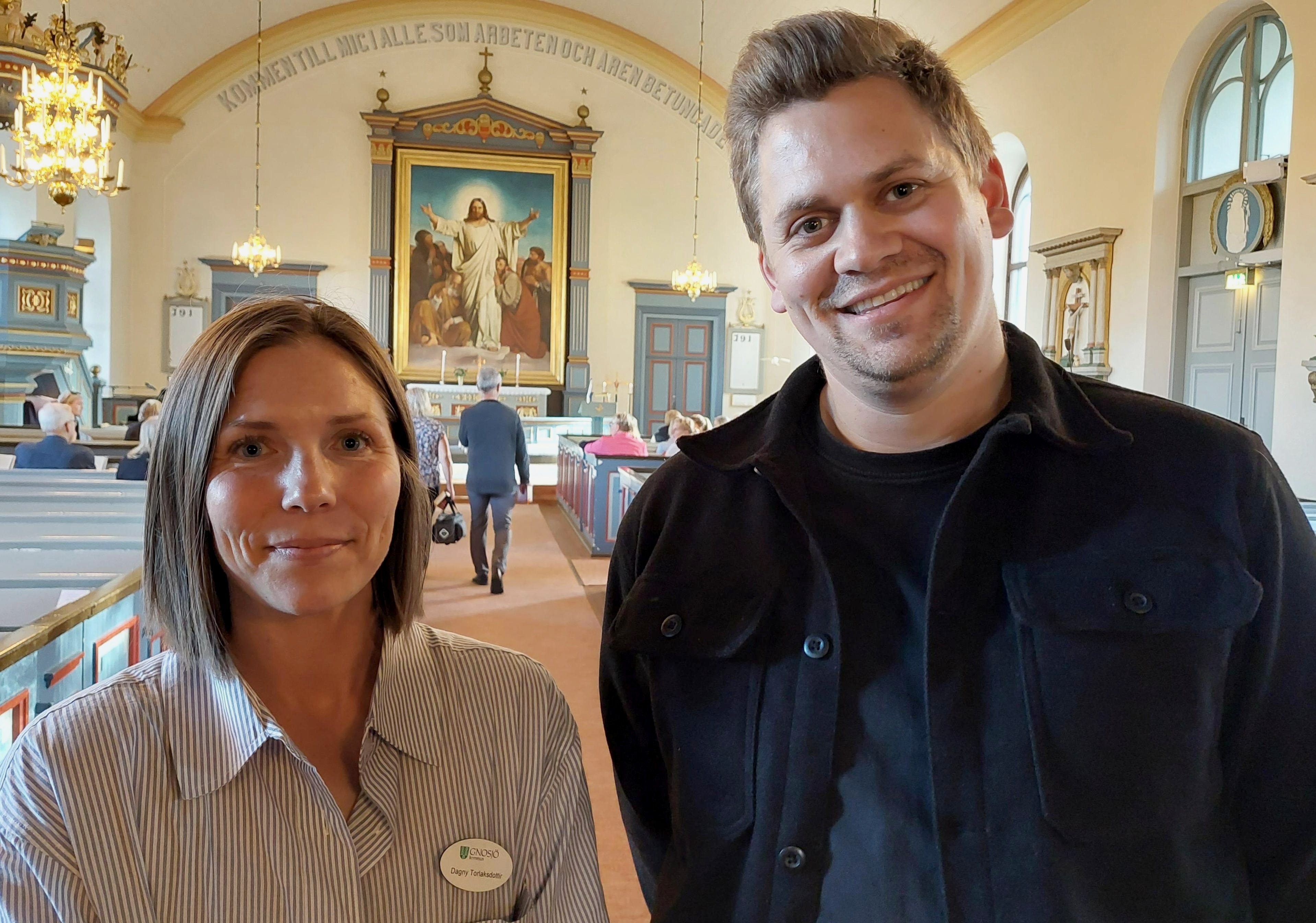 En kvinna och en man står inne i en kyrka.