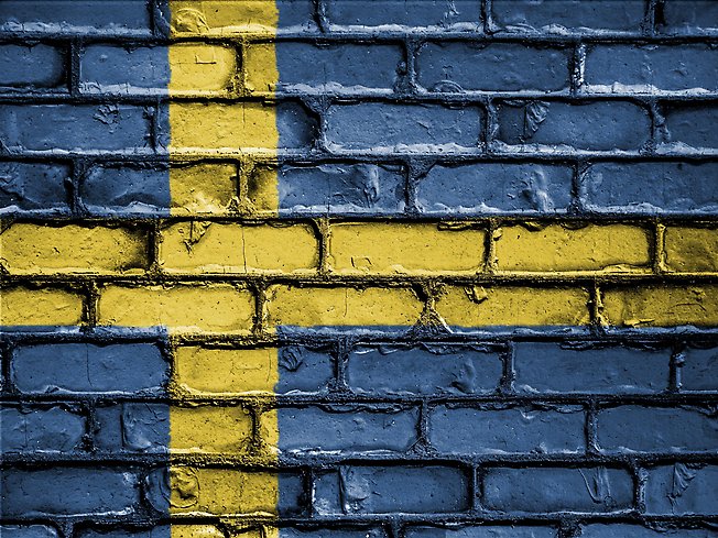 En svensk flagga målad på en tegelvägg.