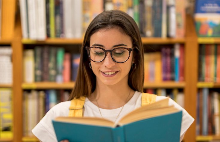 En flicka läser i en bok.