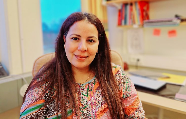 En ung kvinna med bruna ögon och långtlockigt hår.