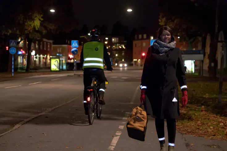 En kvinna klädd i ljus jacka i mörkret.