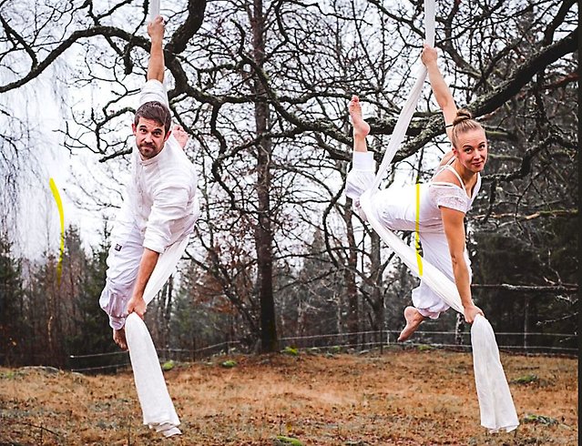 En kille och en tjej i vita kläder, de utför ett nycirkusnummer.