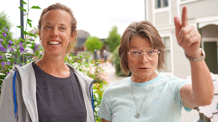 Två glada kvinnor står utomhus i centrum av Gnosjö.