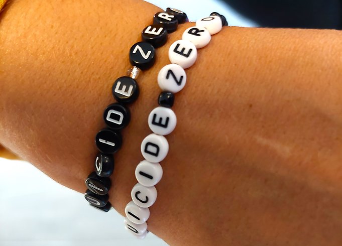 En handled med två SuicideZero-armband. Ett svart och ett vitt.