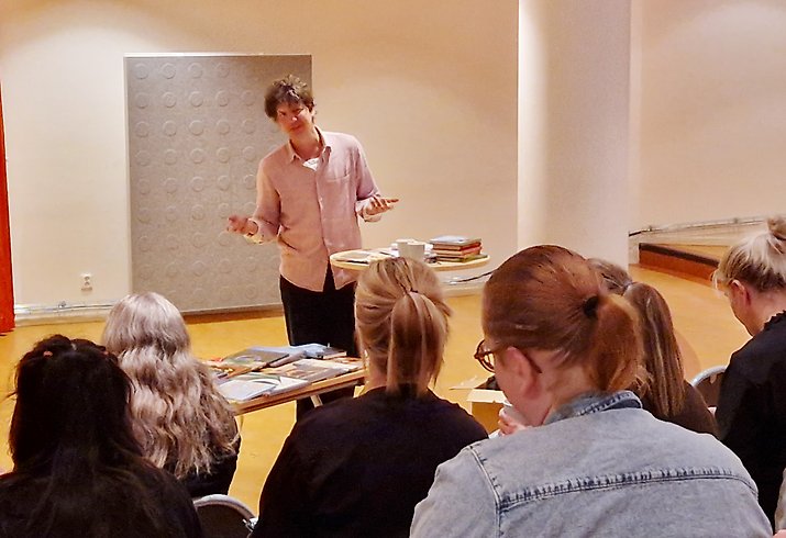 En man föreläser för en grupp åhörare.