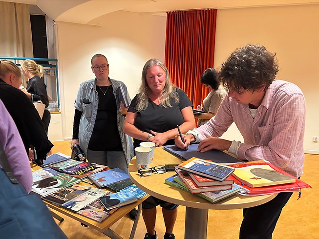 Man som signerar sina böcker.