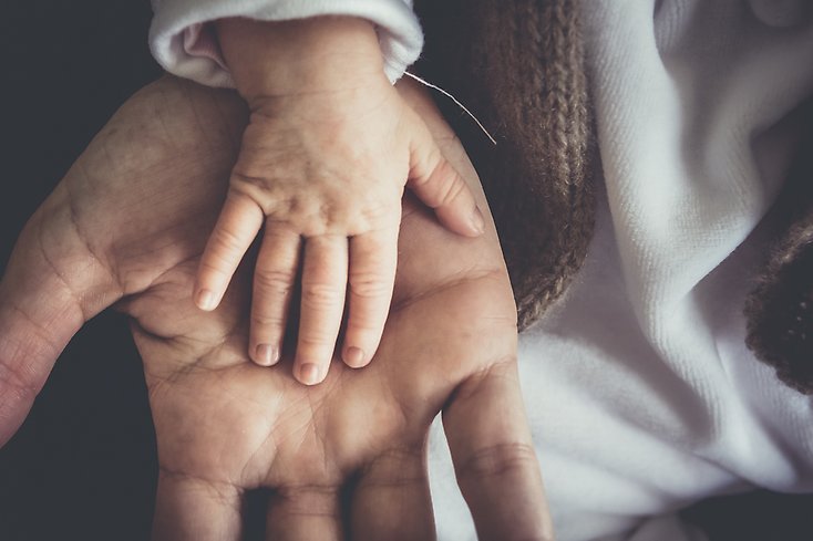 Barnhand i en vuxen person hand.