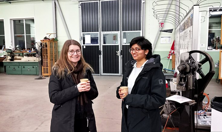 Två kvinnor står i Hylténs Industrimuseum. De ser glada ut.