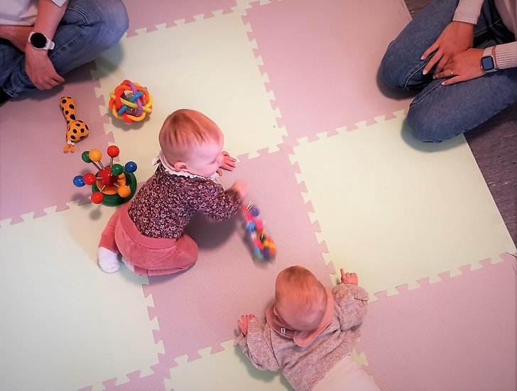 Bebisar på mjukt golv tillsammans med sina föräldrar.