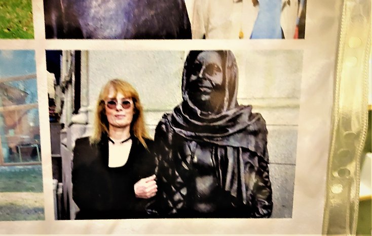 I en plasficka syns ett foto på en staty och en kvinna.