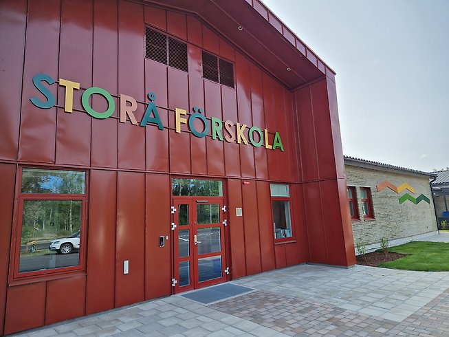 Storå förskola, röd byggnad med färgglada bokstäver med förskolans namn.